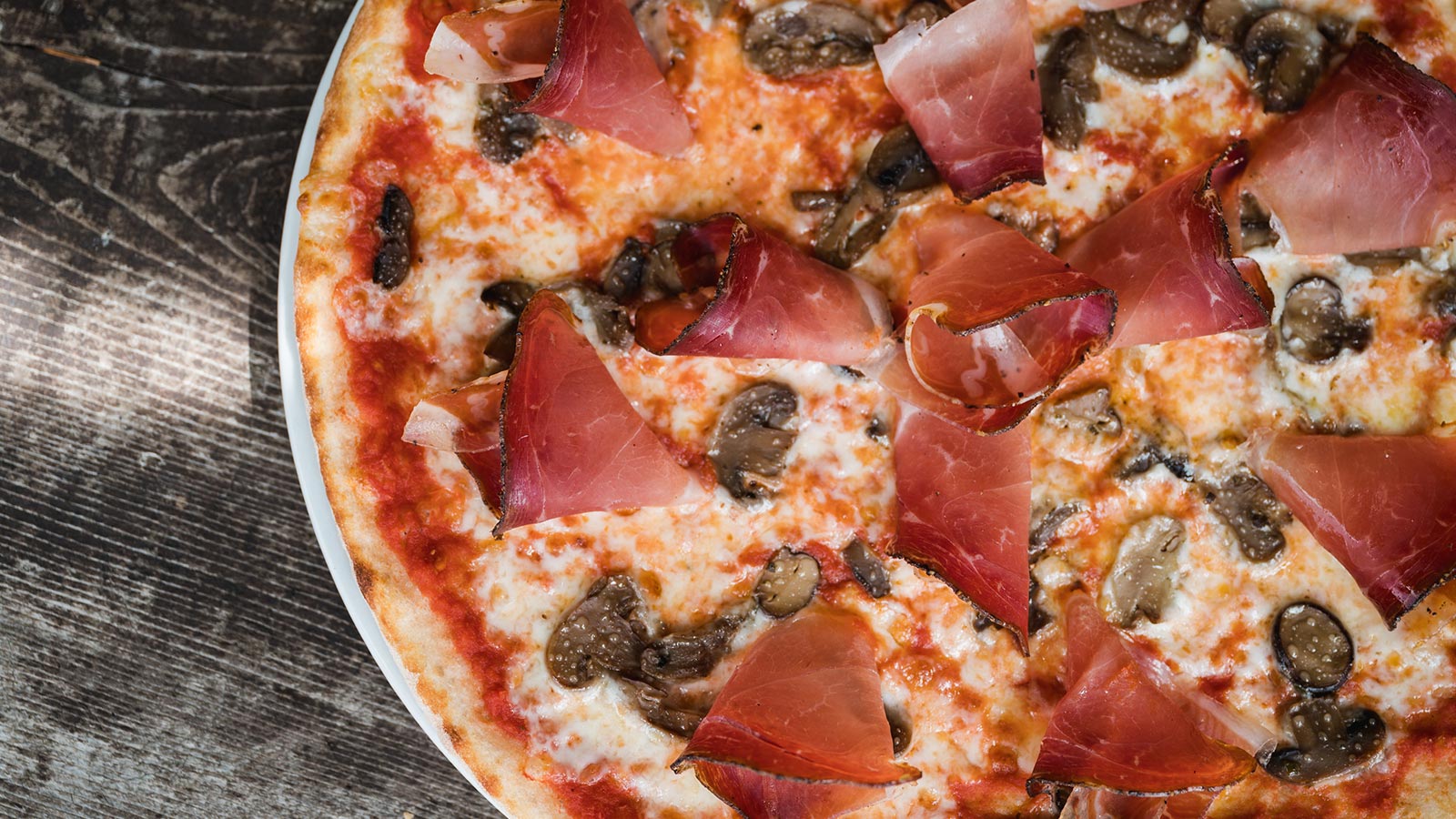 Dettaglio di una pizza con lo speck presso il ristorante dell'Hotel Monte Cherz a Passo Campolongo