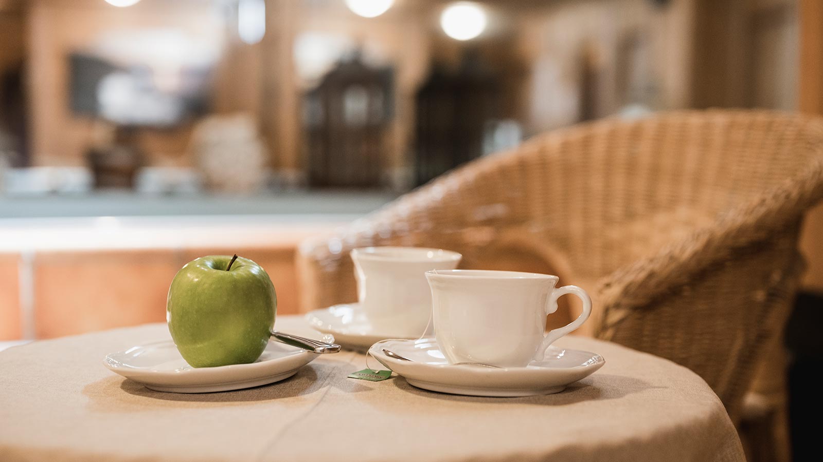 Dettaglio di due tazze di the ed una mela verde presso l'Hotel ad Arabba con centro benessere
